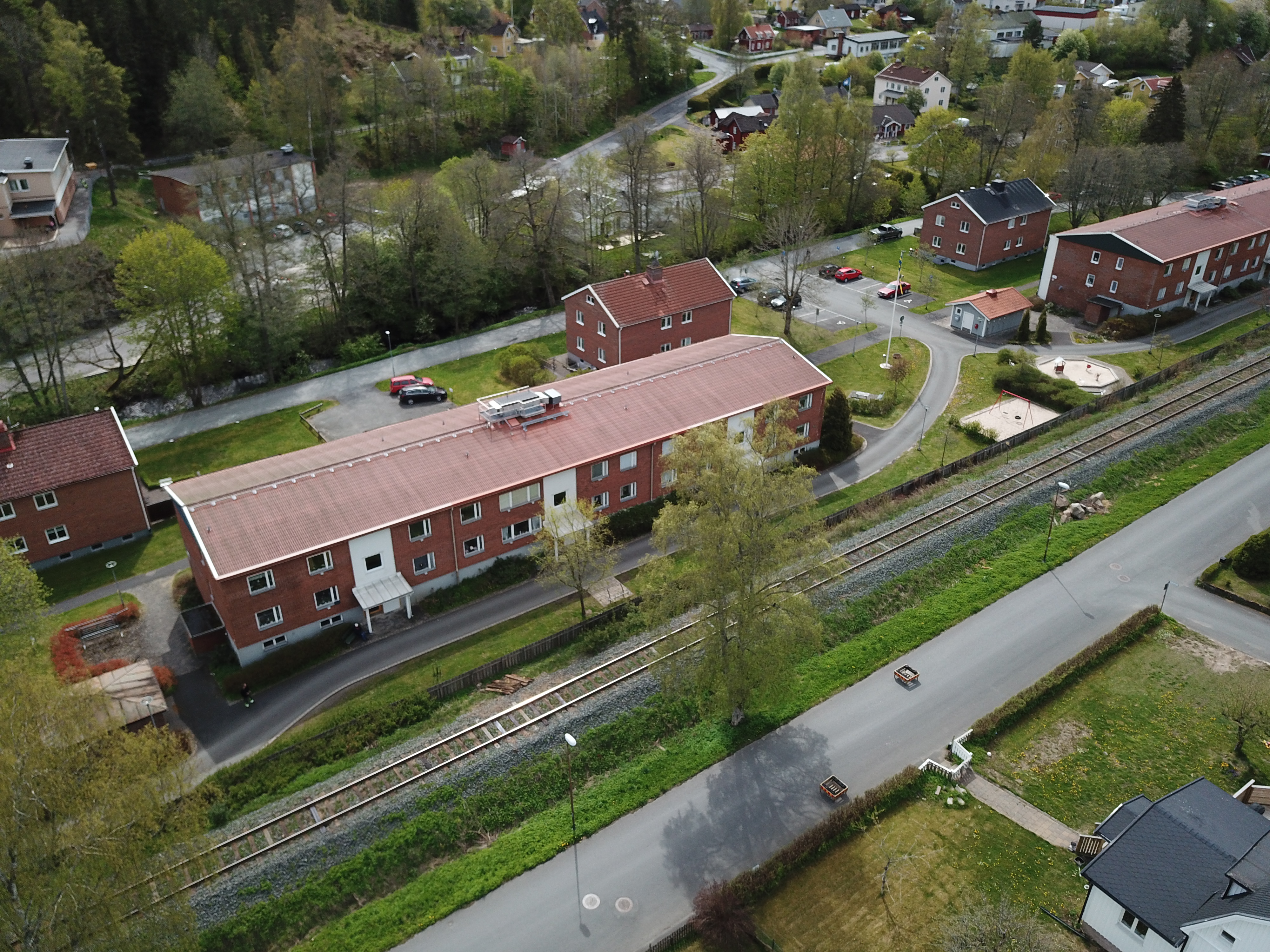 Flygfoto över Ågatan med vy från Viadukten i Norrahammar. Två största husen ägs av Junehem och Tabergsån rinner fram strax intill.